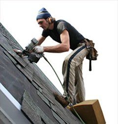 Roofer hand-nailing shingles on a residential roof